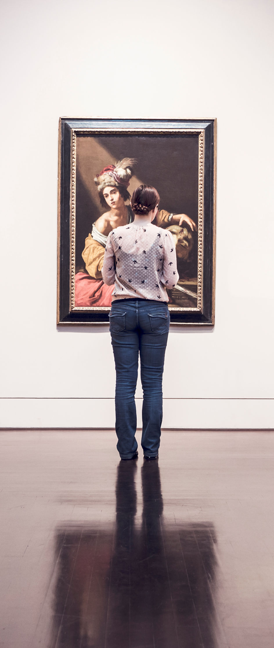 Visitor examining fine art in a gallery